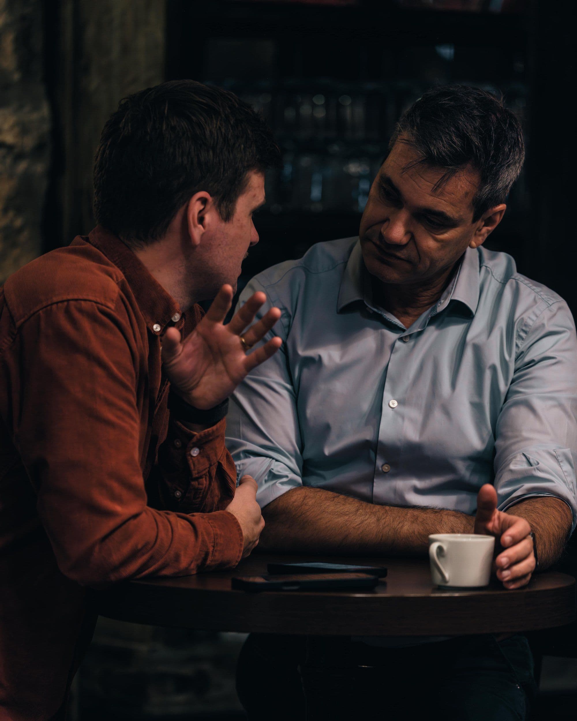 Julian Kranner and Wolfgang Auer in conversation at a table, a coffee cup between them